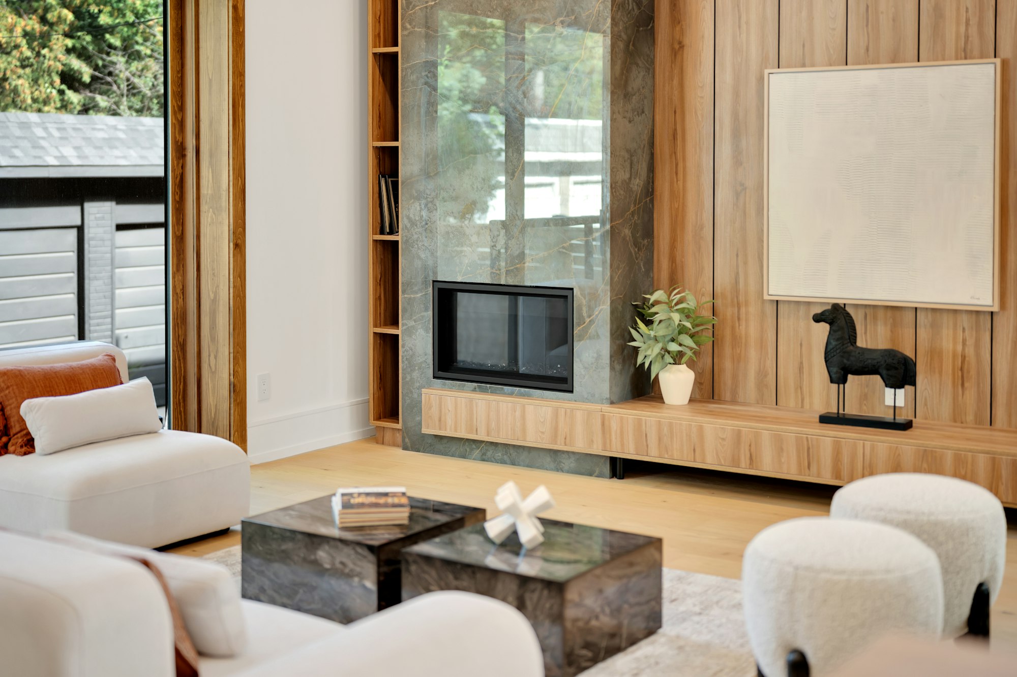 A finished living room with a fireplace and warm daylight